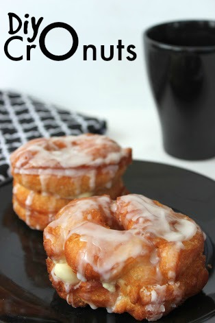 cronuts topped with glaze on a black plate. 