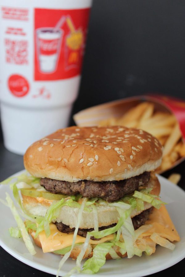 a homemade big mac with 2 burgers, 3 buns, cheese, and lettuce. 