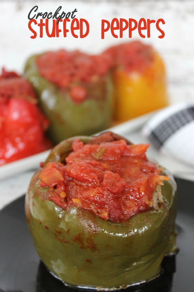 a green bell pepper filled with a rice and tomato mixture with more peppers in the background.