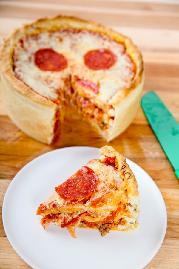 a slice of pizza cake with three layers of crust, cheese, and pepperoni. 