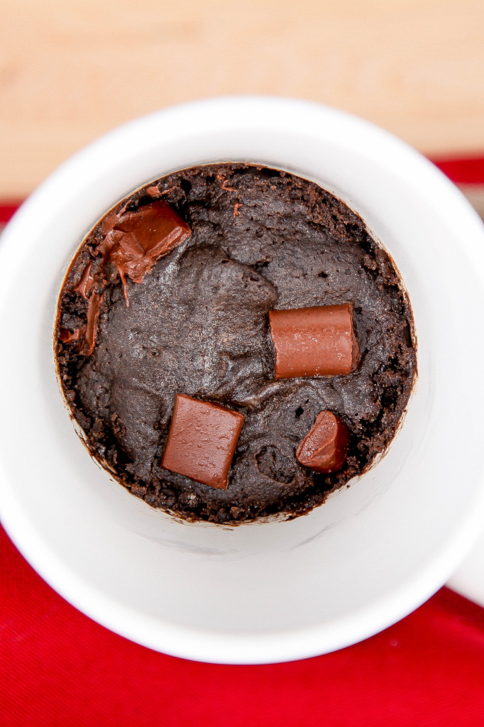 an overhead view of a chocolate chunk brownie made in a white mug. 