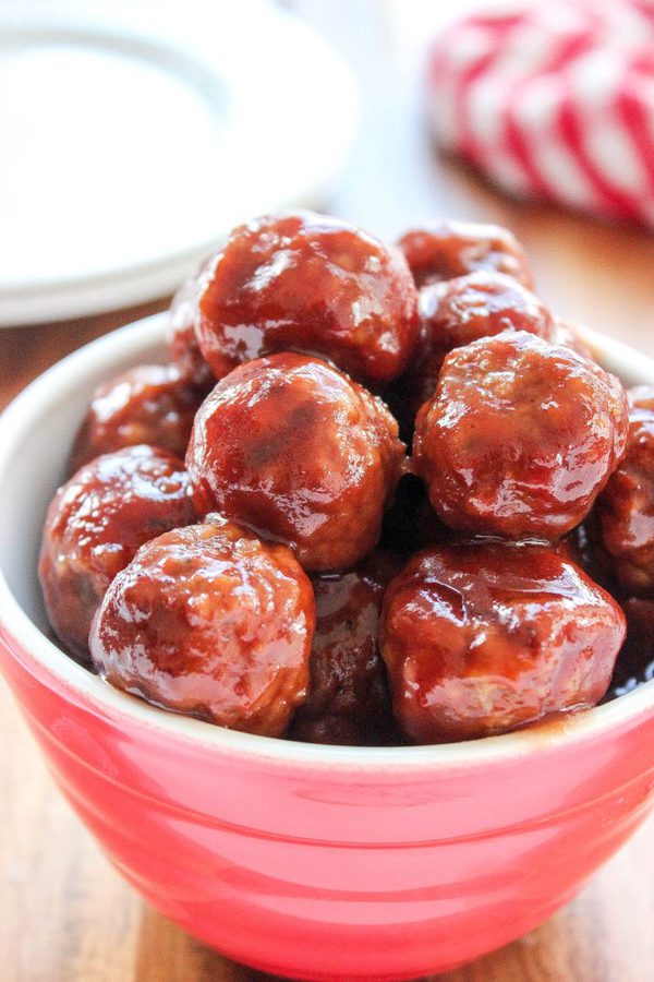 Crock pot meatballs in a sweet and tangy sauce in a red ceramic bowl.