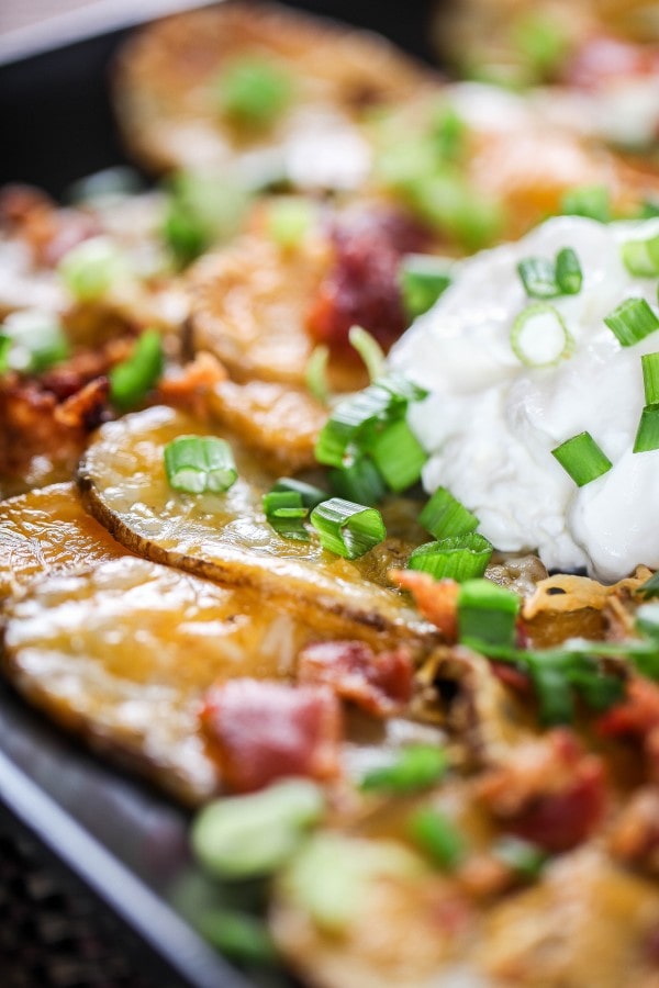 a closeup of Irish nachos topped with sour cream and green onions