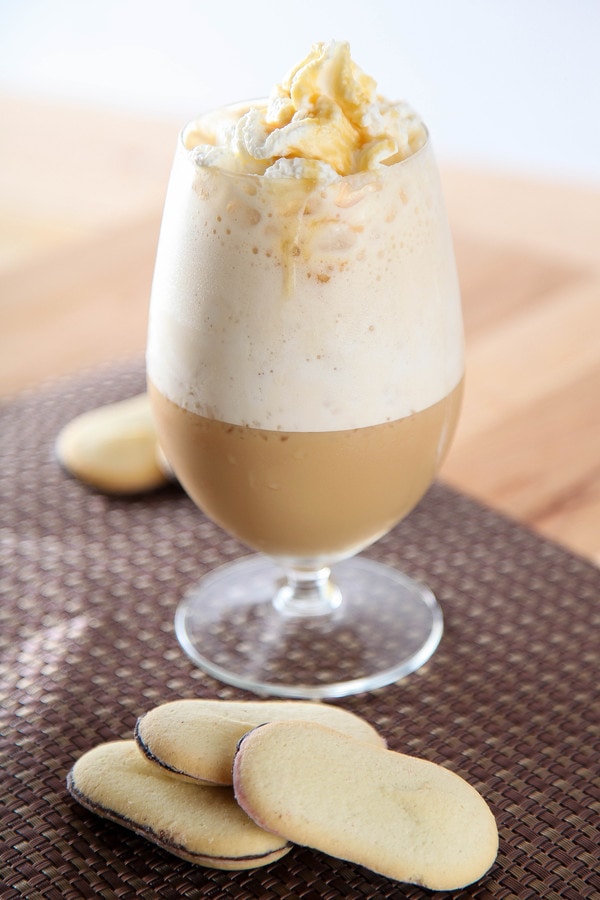 a caramel Frappuccino garnished with whipped cream and caramel sauce.