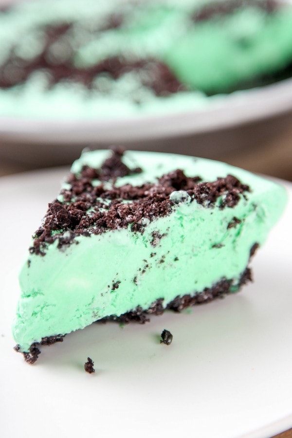 a closeup picture of a boozy green mint pie with an oreo crust. 