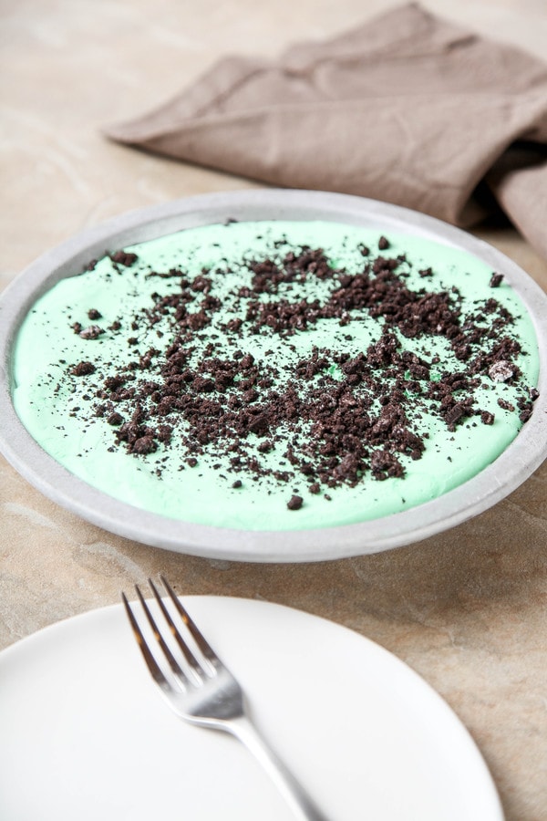 a whole creme de menthe pie in a pie plate with oreos sprinkles on top.