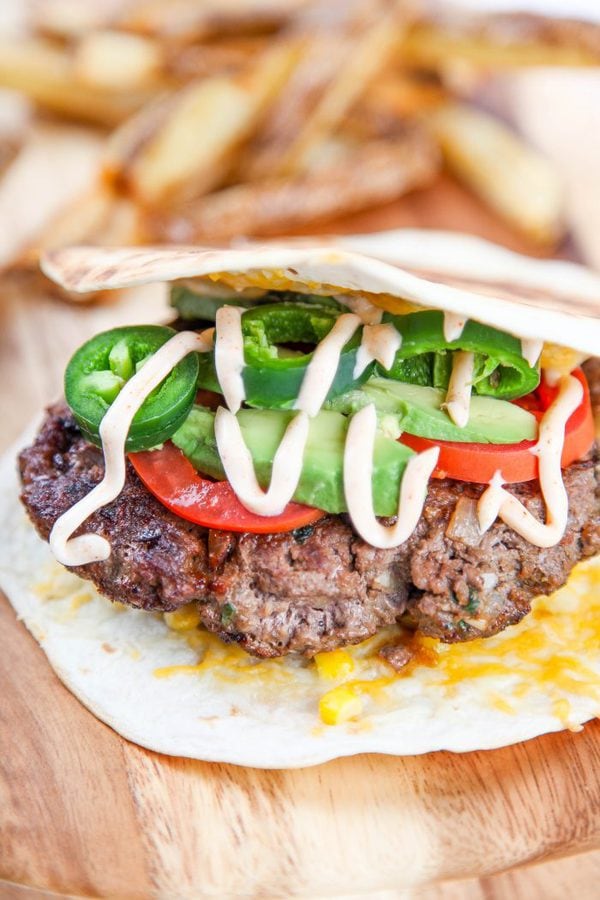 a quesadilla featuring a beef burger, avocado, tomatoes, and a creamy mexican ranch sauce. 