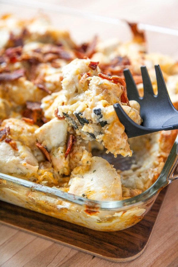 a black claw spatula lifting out a serving of a chicken tater tot casserole.