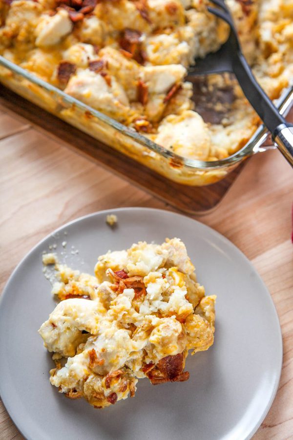 chicken bacon ranch casserole on a gray plate with a casserole dish in the background.