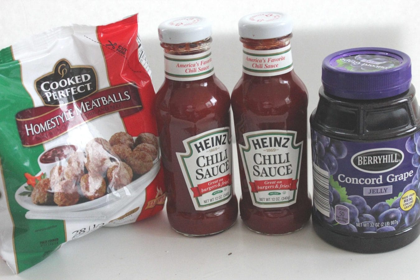 a bag of frozen meatballs, 2 bottles of Heinz chili sauce, and a jar of grape jelly.