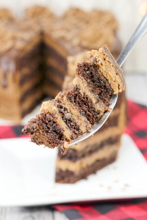 four layers of chocolate cake and frosting on a fork.