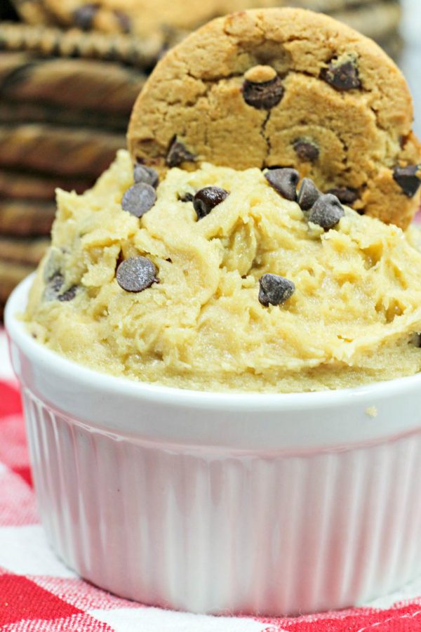 a close up of edible cookie dough topped with chocolate chip and a cookie.