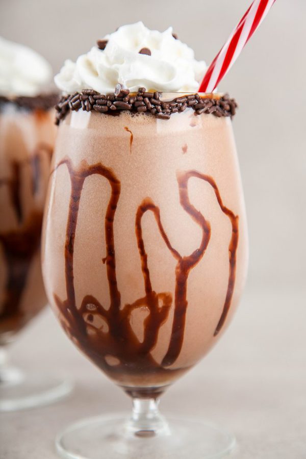 a closeup of a mudslide drink in a glass rimmed with sprinkles with chocolate syrup.