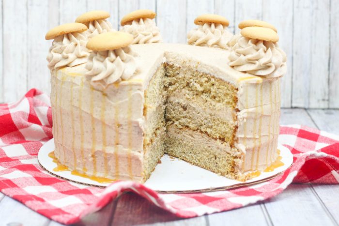 a banana cake cut open to reveal three layers of cake alternating with cinnamon icing.