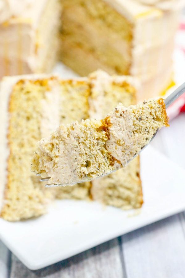 a fork holding a bite of banana cake with cinnamon buttercream.