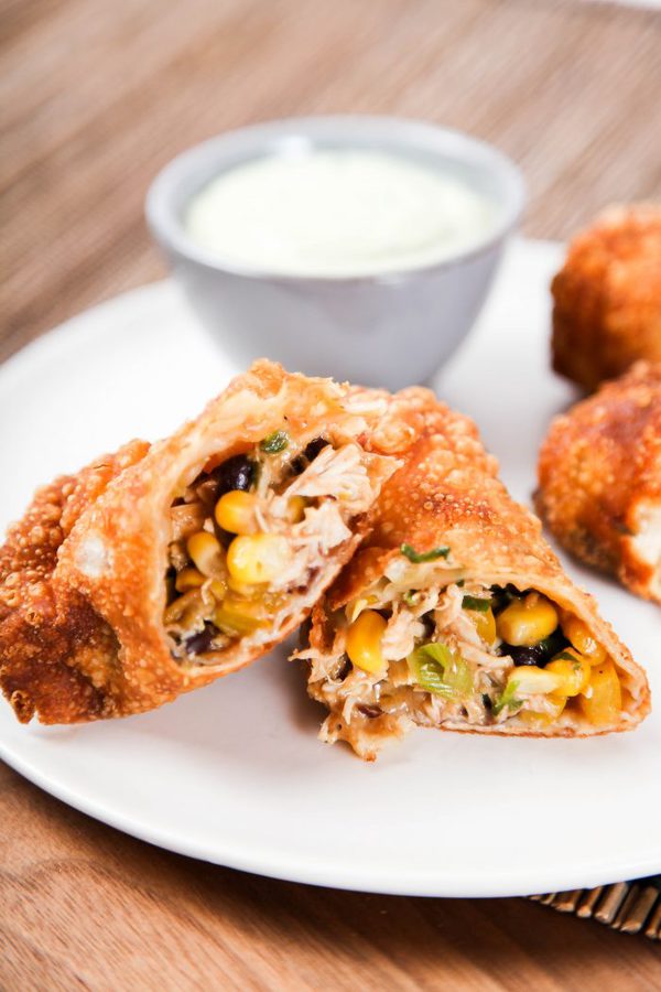 an egg roll cut in half and filled with chicken, corn and black beans.