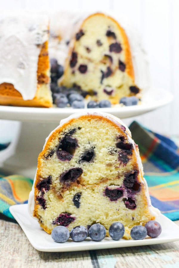 a blueberry bundt cake with a layer of strusel and topped with a white glaze. 