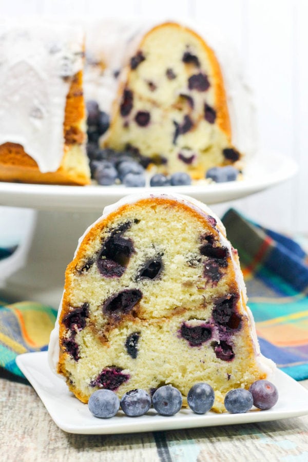 A blueberry bundt cake with a layer of strusel and topped with a white glaze.