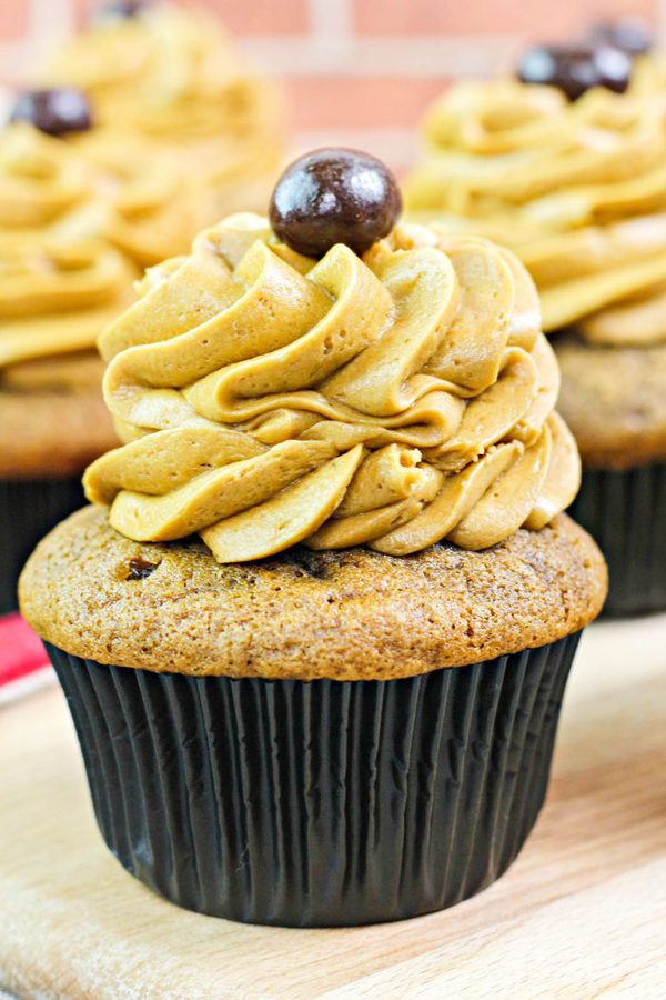 a coffee cupcake topped with coffee buttercream and topped with a chocolate covered espresso bean.