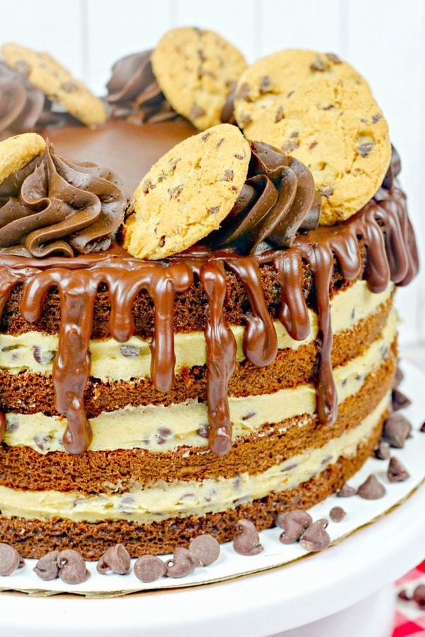 a whole four layer chocolate cake with cookie dough filling, chocolate frosting, and topped with cookies.