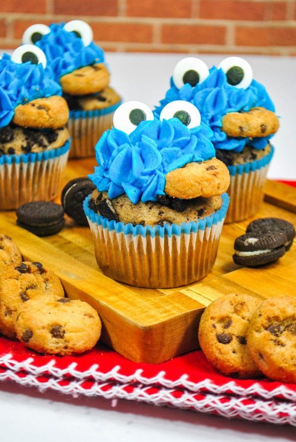 a wooden cutting board with oreo cupcakes and blue buttercream to resemble cookie monster. 
