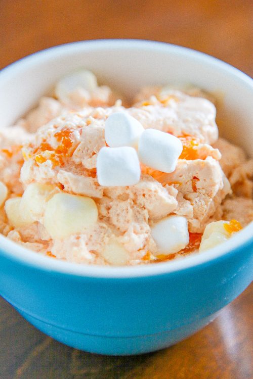orange fluff salad with marshmallows in a blue bowl.