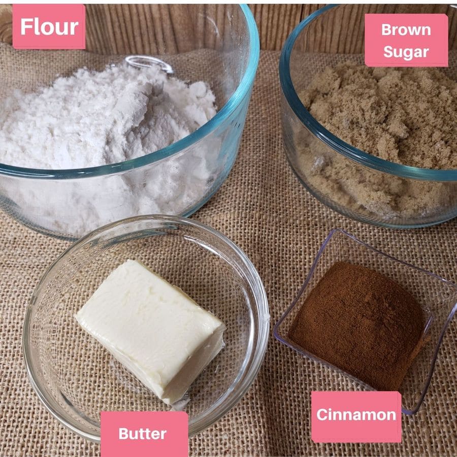 flour, sugar, butter, and cinnamon in clear bowls on a burlap placemat.