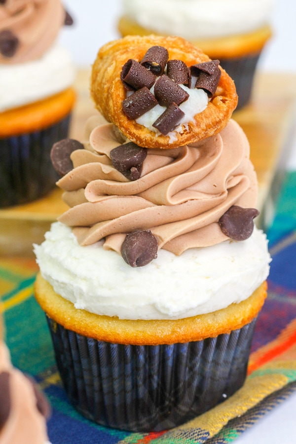 a vanilla cupcake with mascarpone cream, chocolate coffee frosting, and topped with a cannoli.