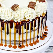 A whole chocolate cake with caramel buttercream and twix bars.