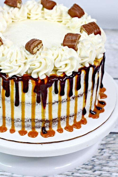 A whole chocolate cake with caramel buttercream and twix bars.