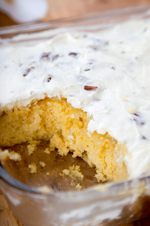 yellow cake with cream cheese icing and pecans in a glass 9x13 pan. 