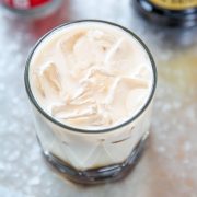 an overhead shot of a cocktail with ice, cream, kahlua, and vodka.