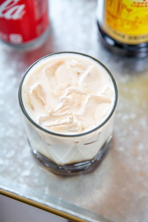 an overhead shot of a cocktail with ice, cream, kahlua, and vodka.