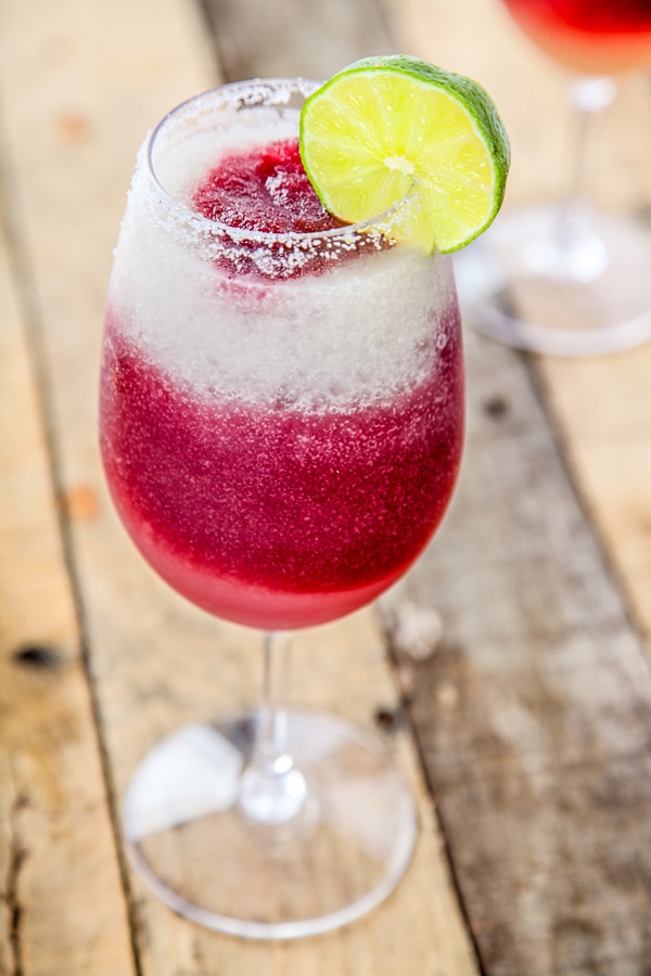 a sangria margarita drink in a wine glass on a wooden table.