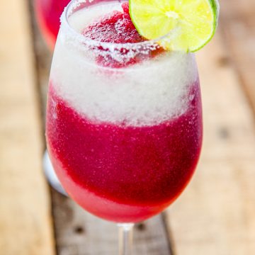 red wine sangria topped with a lime margarita in a wine glass.