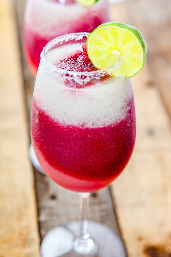 red wine sangria topped with a lime margarita in a wine glass.