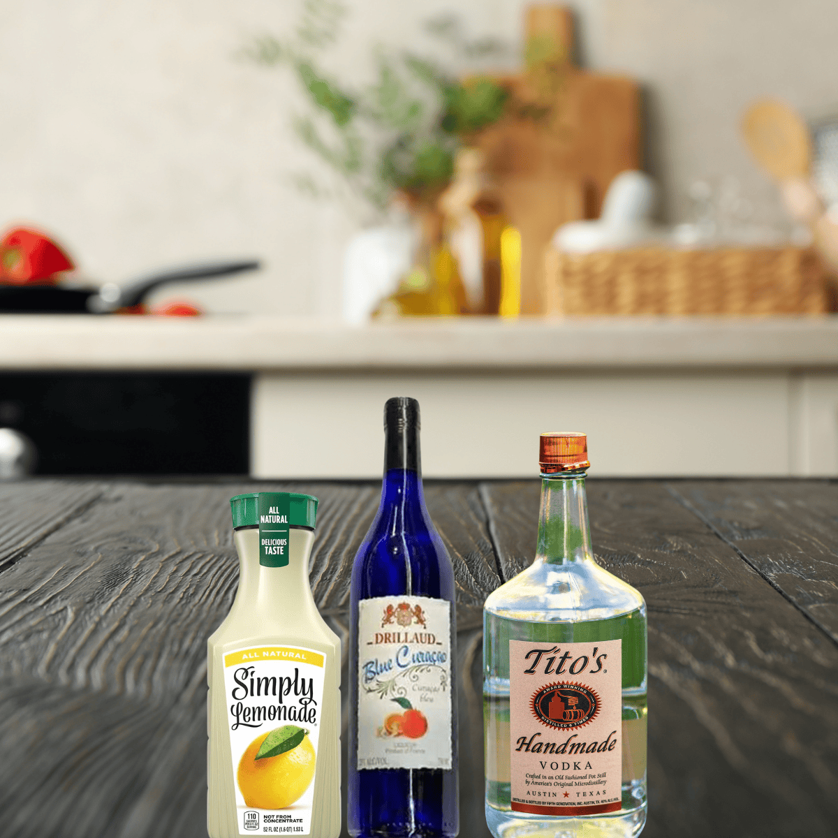 bottles of lemonade, drillaud blue curacao, and tito's vodka on a wooden table. 