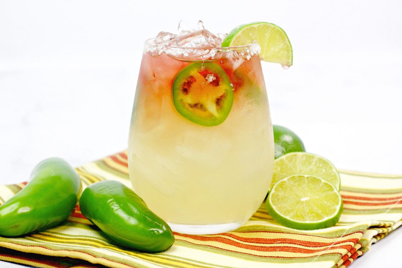 a margarita topped with jalapeno, watermelon liquor,ice and a lime wedge. 