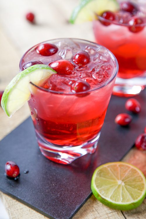 a madras drink garnished with fresh cranberries and a lime wedge. 