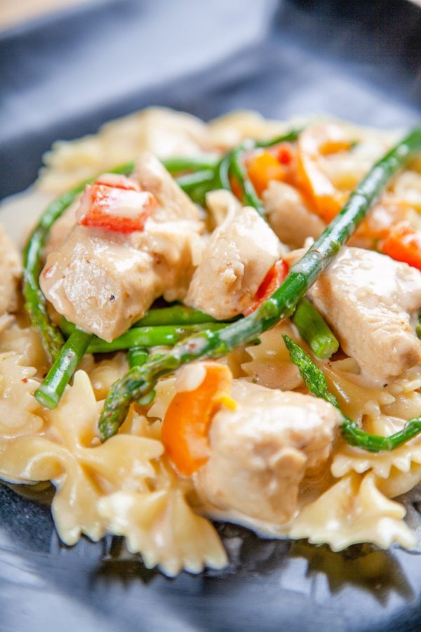 Chicken Chipotle Pasta with orange bell pepper, and asparagus in a cream sauce.