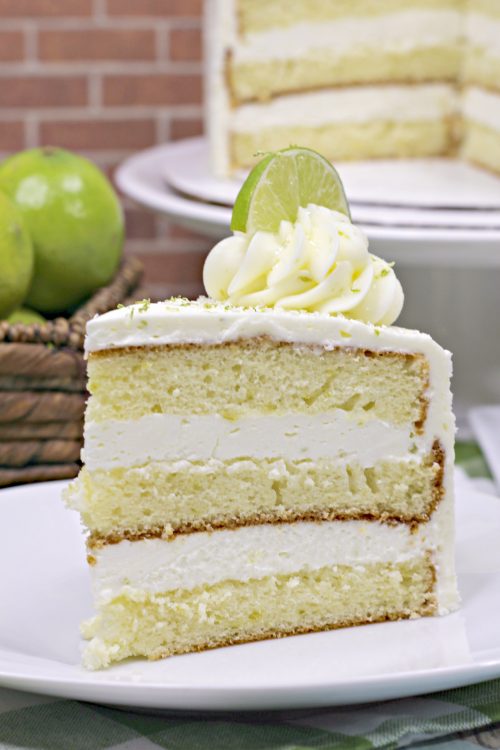 a slice of margarita cake topped with lime buttercream and a lime slice.