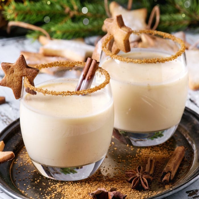 two cinnamon rumchata cocktails garnished with a cinnamon stick and a star cookie.