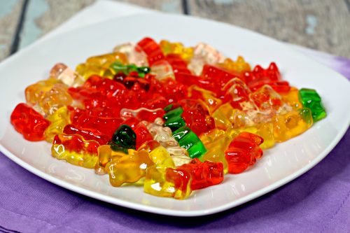pineapple rum soaked gummy bears on a white plate.