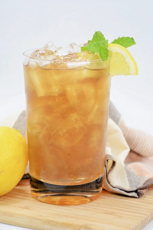 a long island iced tea with ice, mint, and a lemon wedge.