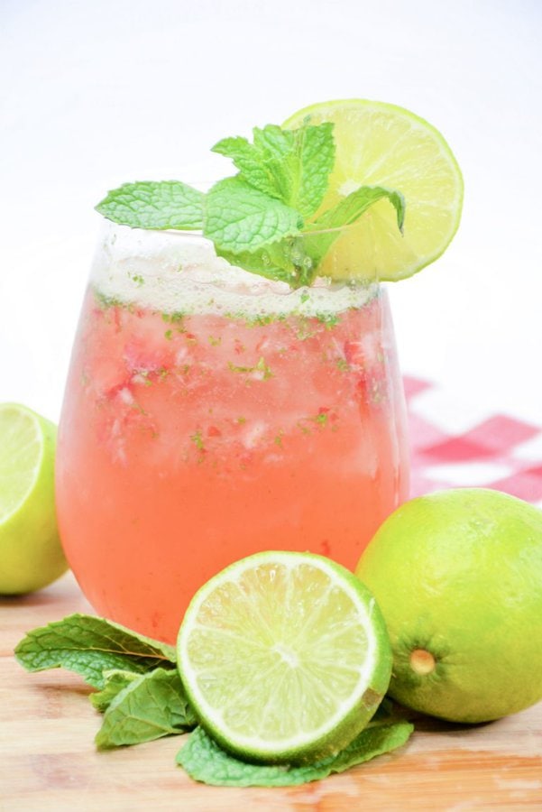 a strawberry mojito garnished with lime and mint.