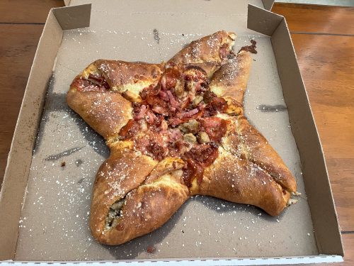 the 4 quarter calzone from little caesars with meat toppings in a pizza box.