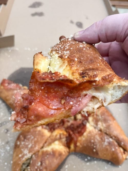a slice of the 4 quarter calzony with pepperoni, bacon, and ham. 