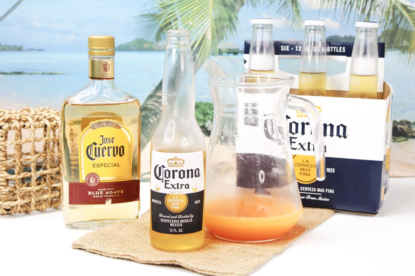 corona beer, with a sunrise cocktail in a large clear pitcher.