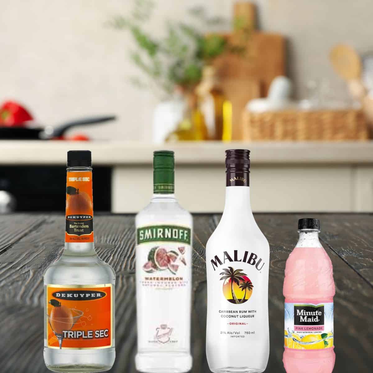 triple sec, watermelon vodka, rum, and pink lemonade on a counter. 
