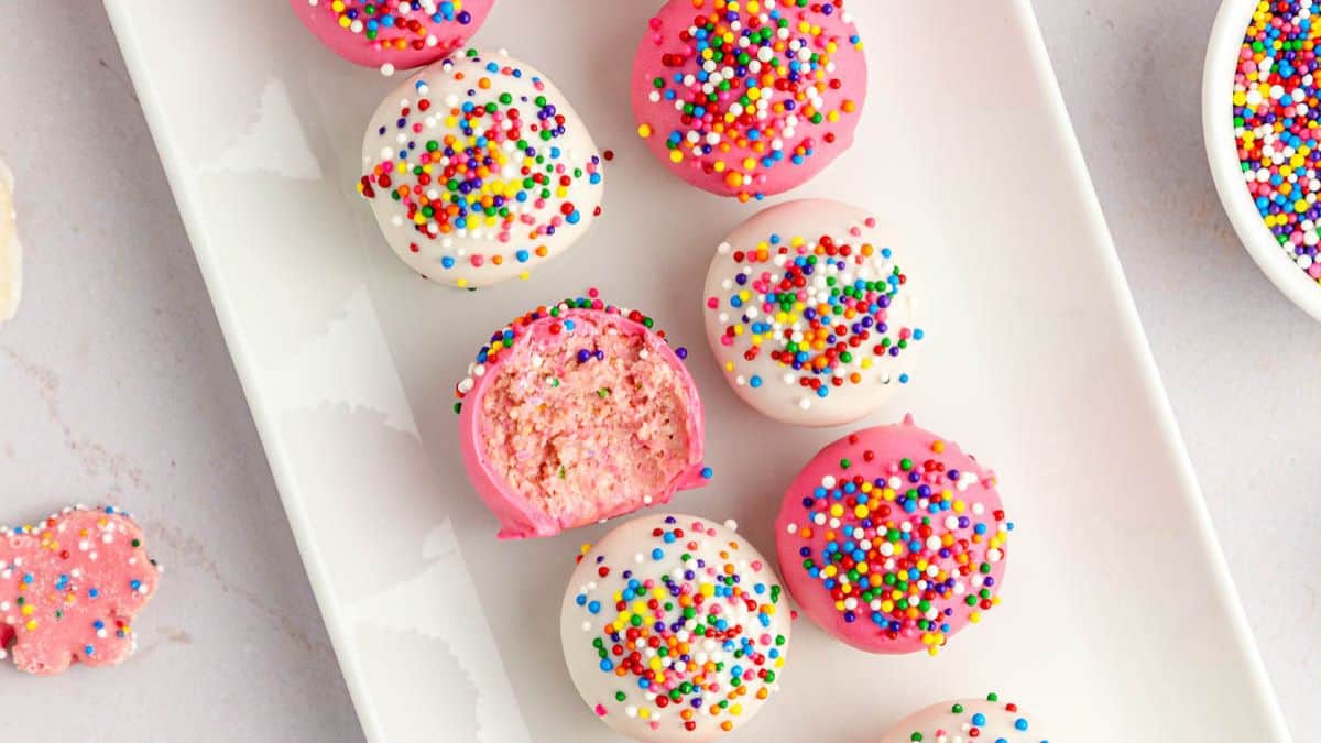 A plate of truffles dipped in white or pink candy coating.
